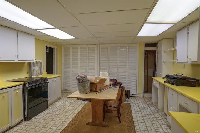 kitchen with a drop ceiling, white cabinetry, and black range with electric stovetop