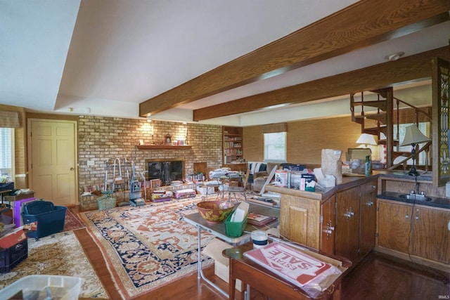 living room with brick wall, hardwood / wood-style flooring, and a fireplace