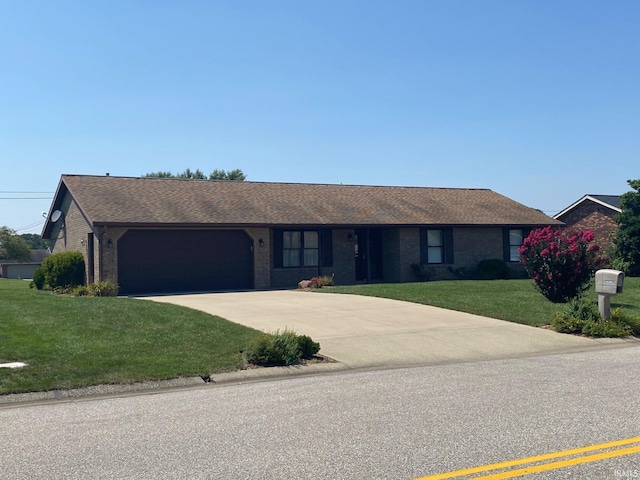 ranch-style home with a garage, a front yard, brick siding, and driveway