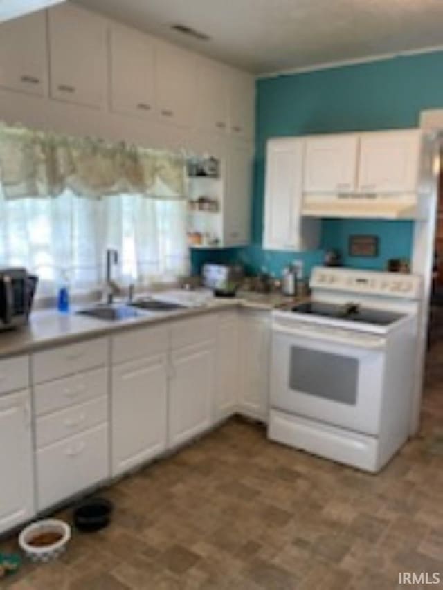 kitchen with sink, white electric range, light tile patterned floors, and white cabinetry