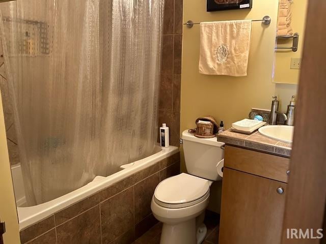 full bathroom featuring shower / bath combo with shower curtain, vanity, and toilet