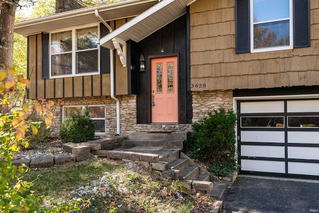 property entrance with stone siding and a garage