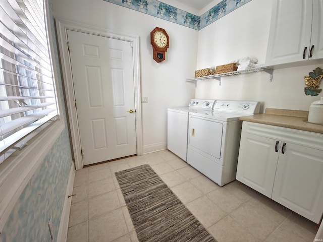 clothes washing area featuring cabinet space, baseboards, washer and clothes dryer, and light tile patterned flooring