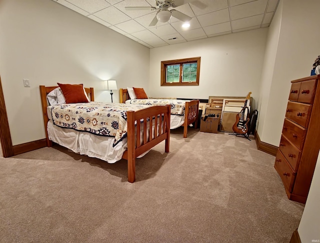 carpeted bedroom featuring a paneled ceiling, ceiling fan, and baseboards