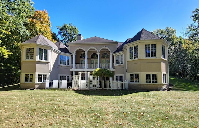 rear view of property featuring brick siding, a lawn, and a chimney