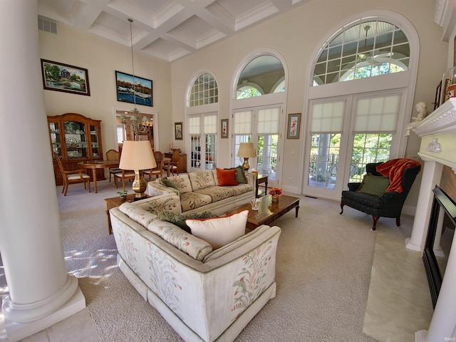 living area with a high ceiling, coffered ceiling, beamed ceiling, decorative columns, and an inviting chandelier