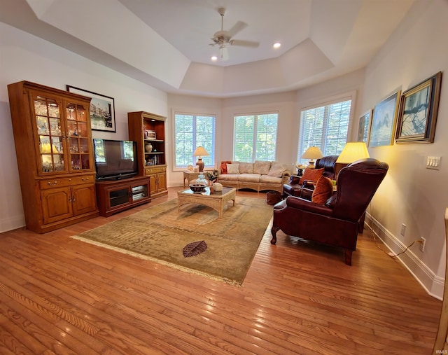 living room featuring baseboards, a wealth of natural light, and light wood-style floors