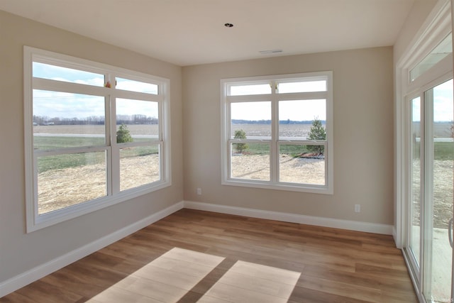 empty room with light hardwood / wood-style flooring and a rural view