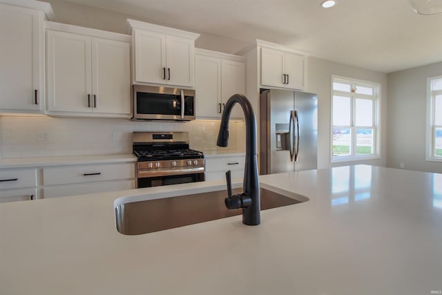 kitchen featuring white cabinets, decorative backsplash, and appliances with stainless steel finishes