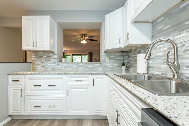 kitchen featuring white cabinets, backsplash, light hardwood / wood-style flooring, and sink