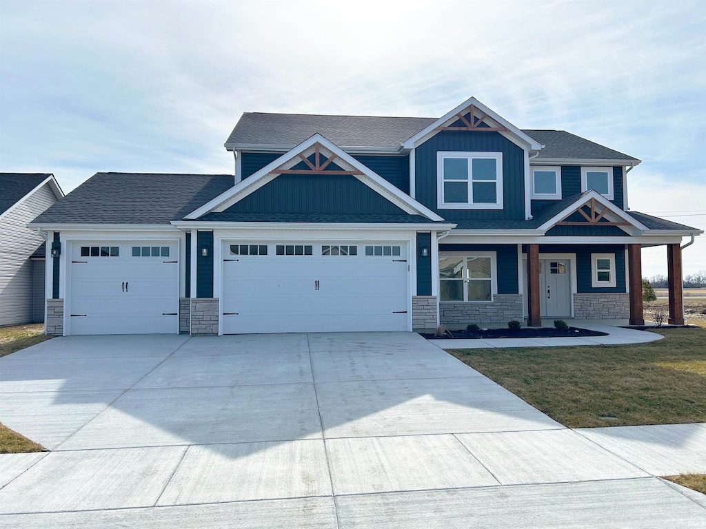 craftsman inspired home with a garage and a front yard