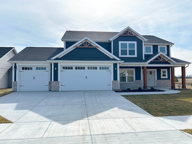 craftsman inspired home with a garage and a front yard