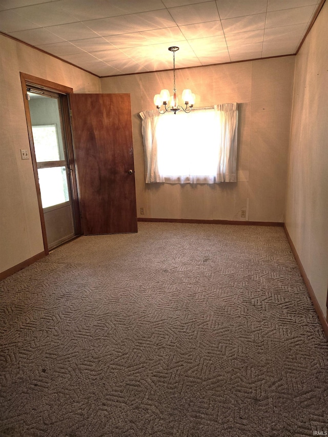 carpeted empty room with an inviting chandelier