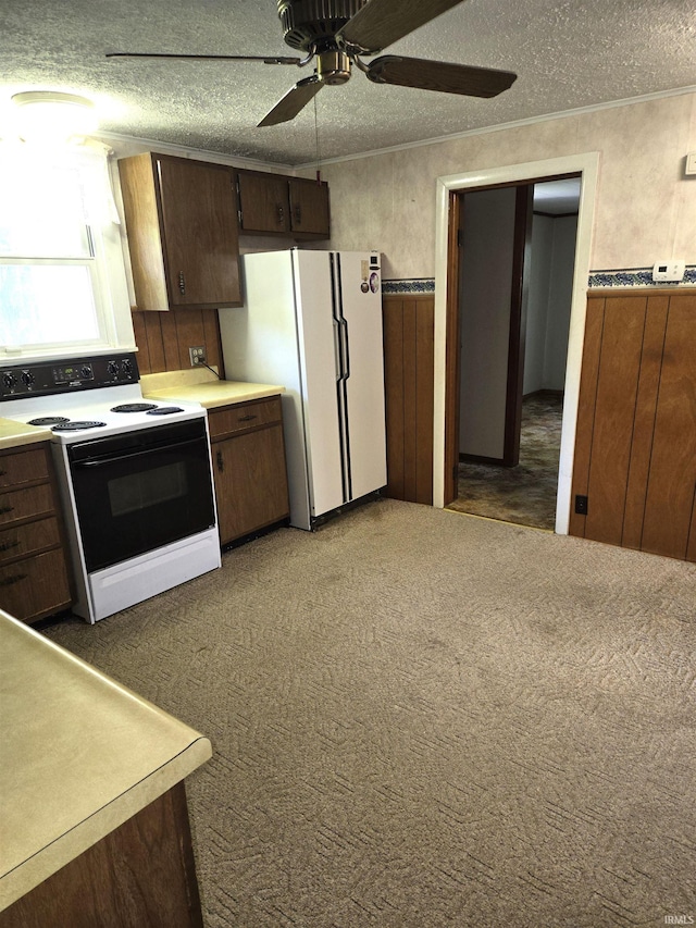 kitchen featuring a textured ceiling, ceiling fan, white appliances, and light colored carpet