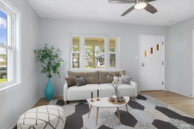 living room with ceiling fan, wood-type flooring, and a healthy amount of sunlight