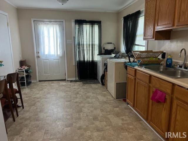 kitchen with ornamental molding, sink, and light tile patterned floors