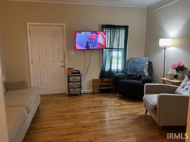 living area featuring hardwood / wood-style flooring and ornamental molding