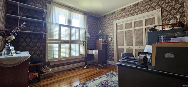 office space featuring baseboards, wallpapered walls, crown molding, and wood finished floors