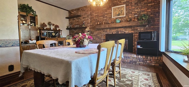 dining area with wood finished floors and a brick fireplace