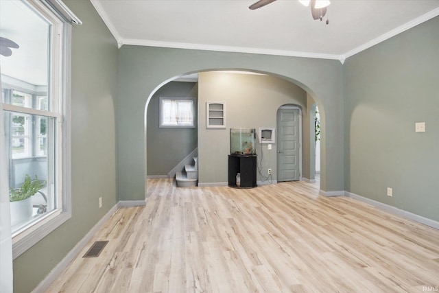 unfurnished living room with ornamental molding, a healthy amount of sunlight, ceiling fan, and light wood-type flooring