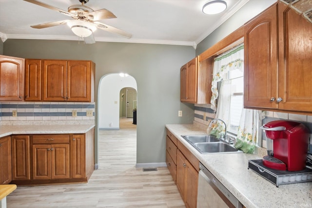 kitchen with light hardwood / wood-style floors, stainless steel dishwasher, a wealth of natural light, and backsplash