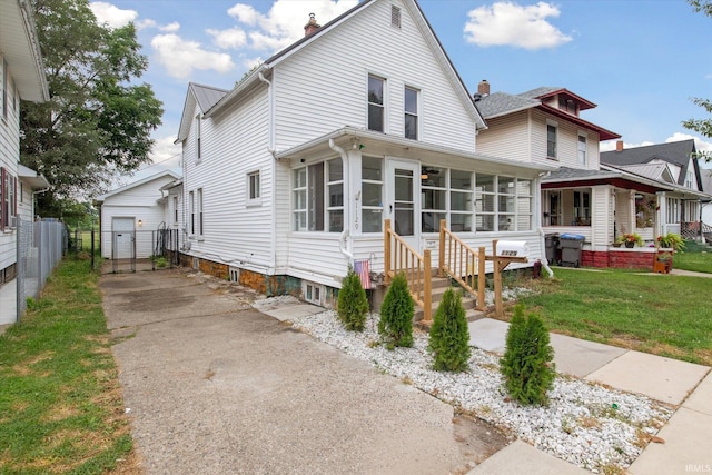 back of house with a sunroom and a yard