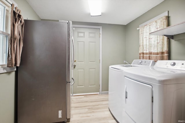 washroom with separate washer and dryer and light hardwood / wood-style flooring