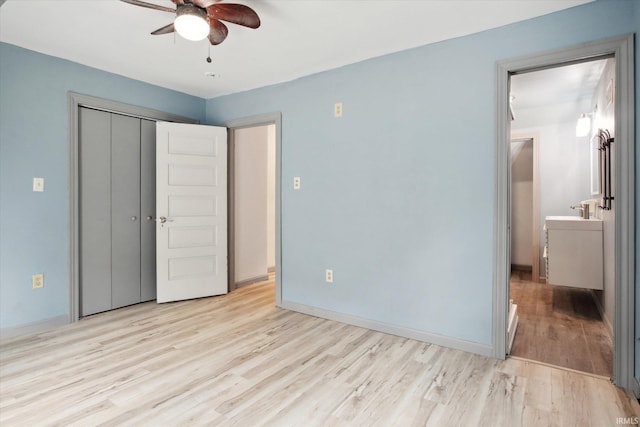 unfurnished bedroom with light hardwood / wood-style floors, sink, a closet, and ceiling fan