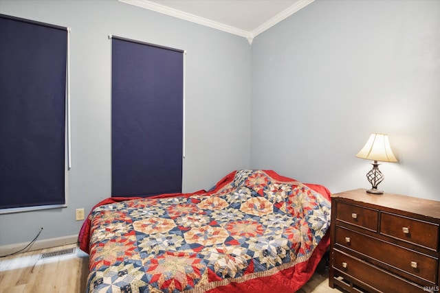 bedroom with ornamental molding and light hardwood / wood-style floors