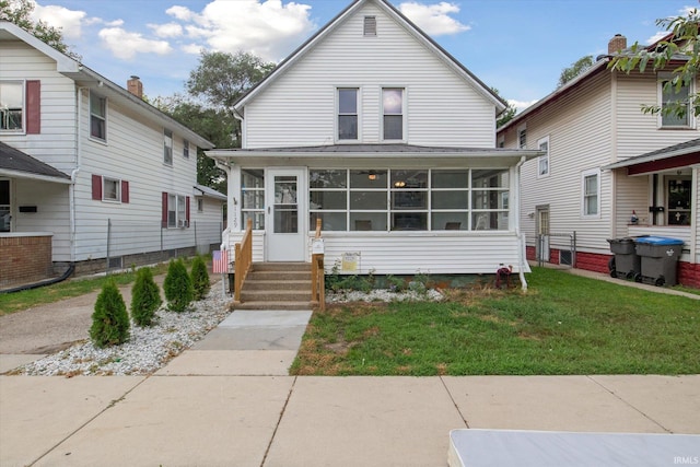 bungalow featuring a sunroom and a front lawn