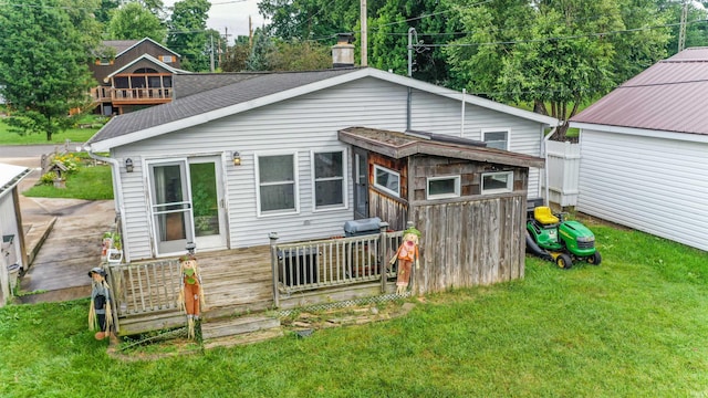 rear view of property with a lawn and a deck