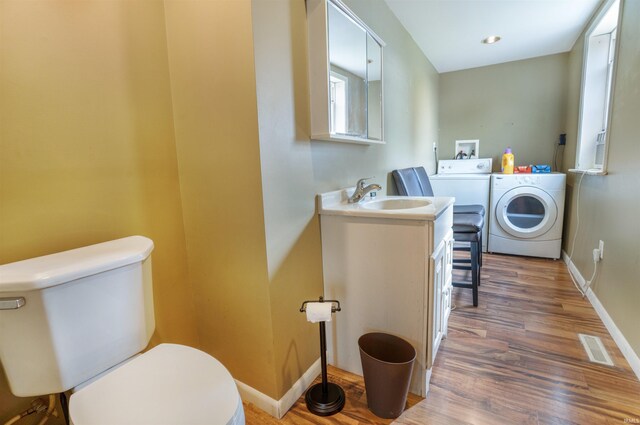 bathroom with vanity, washer and dryer, hardwood / wood-style floors, and toilet