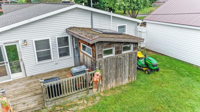 back of property with a yard and a deck