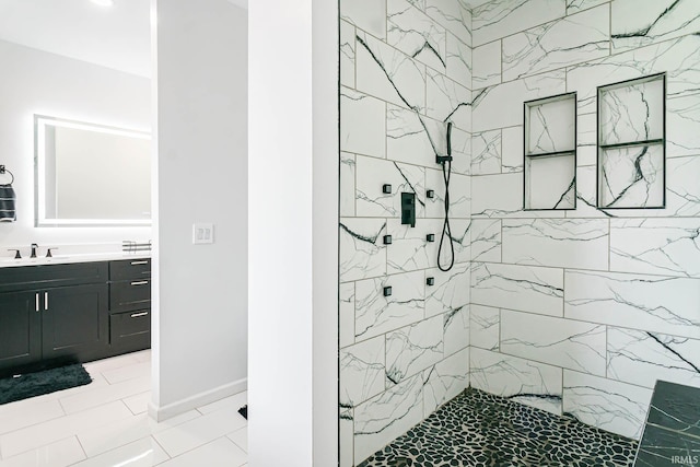 bathroom with tile patterned floors, vanity, and tiled shower