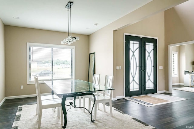 dining area with an inviting chandelier, french doors, and dark wood-type flooring