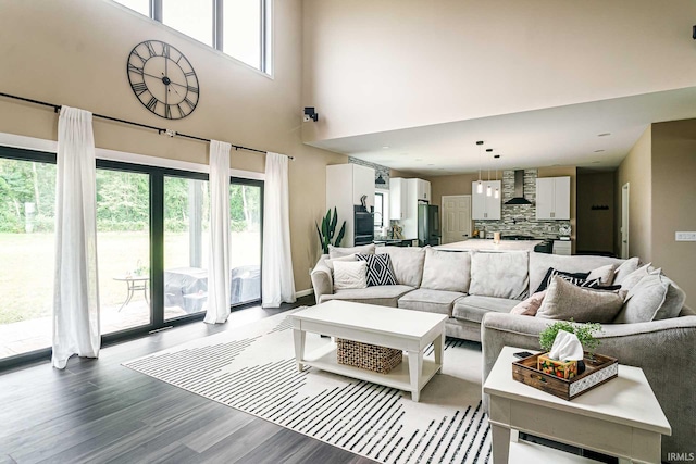 living room featuring hardwood / wood-style flooring and a towering ceiling