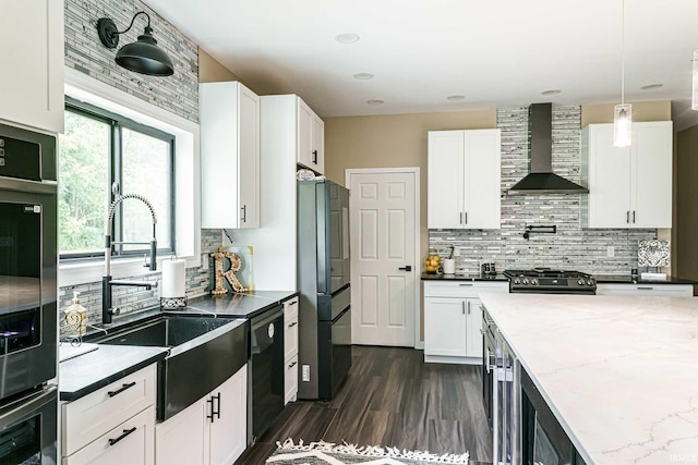 kitchen featuring decorative light fixtures, dishwashing machine, tasteful backsplash, wall chimney exhaust hood, and black fridge