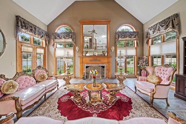 living room with high vaulted ceiling, a fireplace, ceiling fan, and tile patterned floors