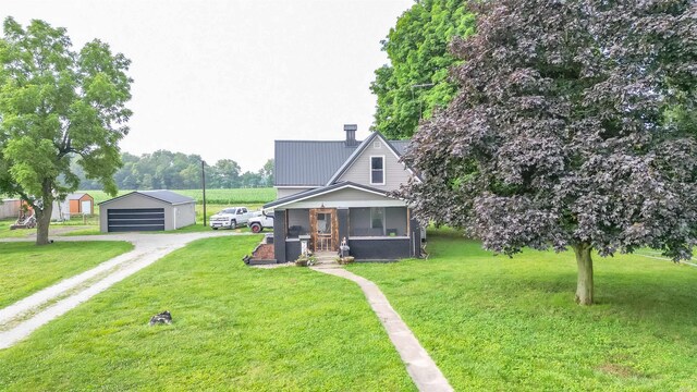 view of front facade with a garage, an outbuilding, and a front lawn