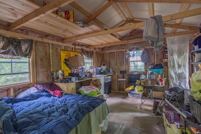 bedroom with concrete flooring and vaulted ceiling