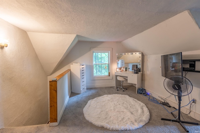 home office featuring lofted ceiling, carpet, and a textured ceiling