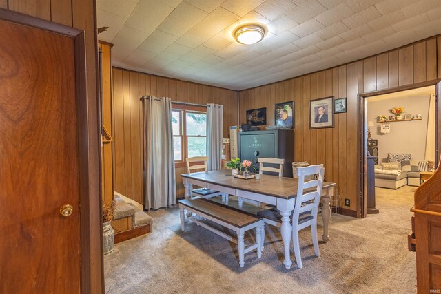 carpeted office space featuring wood walls