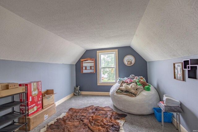 recreation room featuring vaulted ceiling, a textured ceiling, and carpet flooring