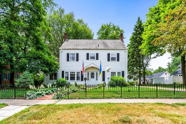 colonial inspired home with a front lawn