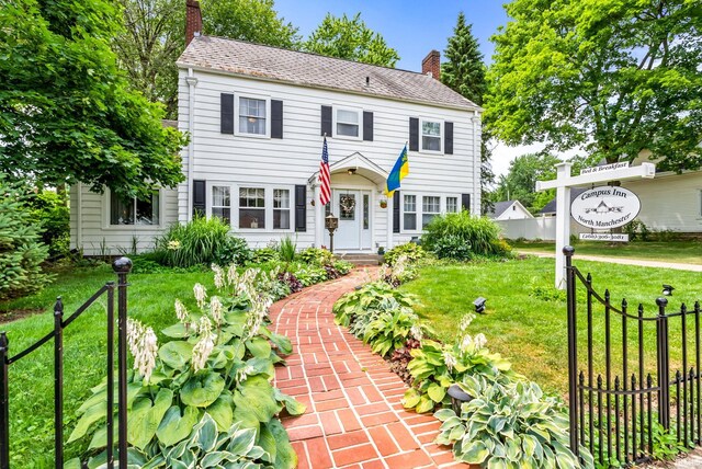 colonial house featuring a front lawn