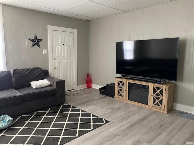 living room with hardwood / wood-style flooring and a paneled ceiling