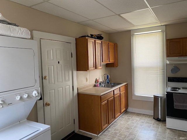 435 16th St, Bedford, IN 47421 - kitchen featuring stacked washer / drying machine, a sink, brown cabinets, under cabinet range hood, and electric range