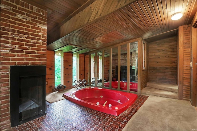 bathroom with a jetted tub, wooden ceiling, a fireplace, and wooden walls