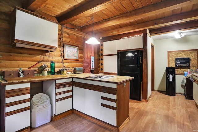 kitchen with light wood-type flooring, wood ceiling, black refrigerator, log walls, and beamed ceiling