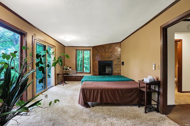 bedroom with wood walls, ornamental molding, carpet floors, and a large fireplace